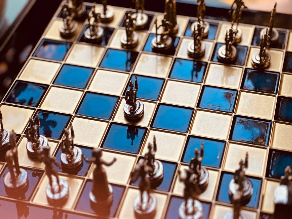 Šahovska tabla so metalni figuri, simbol na strategijata za 21 godina Vatra